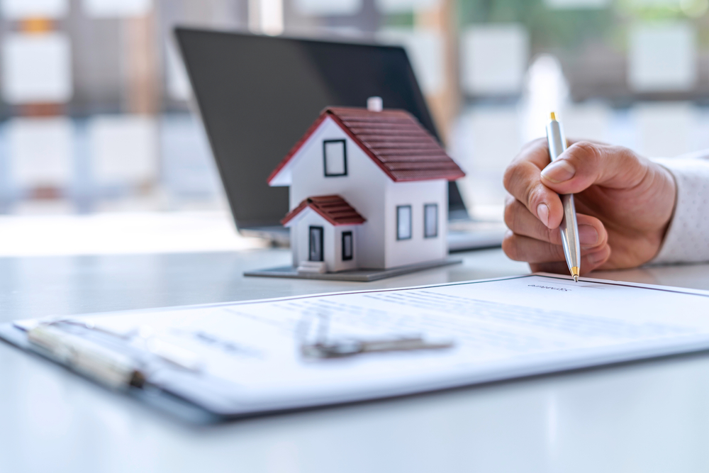 New homebuyers are signing a contract to buy or sell a home at an agent's desk to meet the deal, purchase contract concept. ©CrizzyStudio